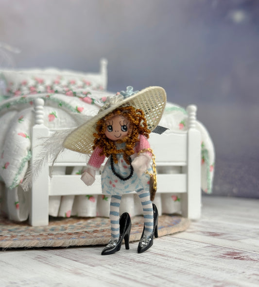Tiny Clay Little Toy Dolly in Dress Up Clothes & Heels, in front of a bed