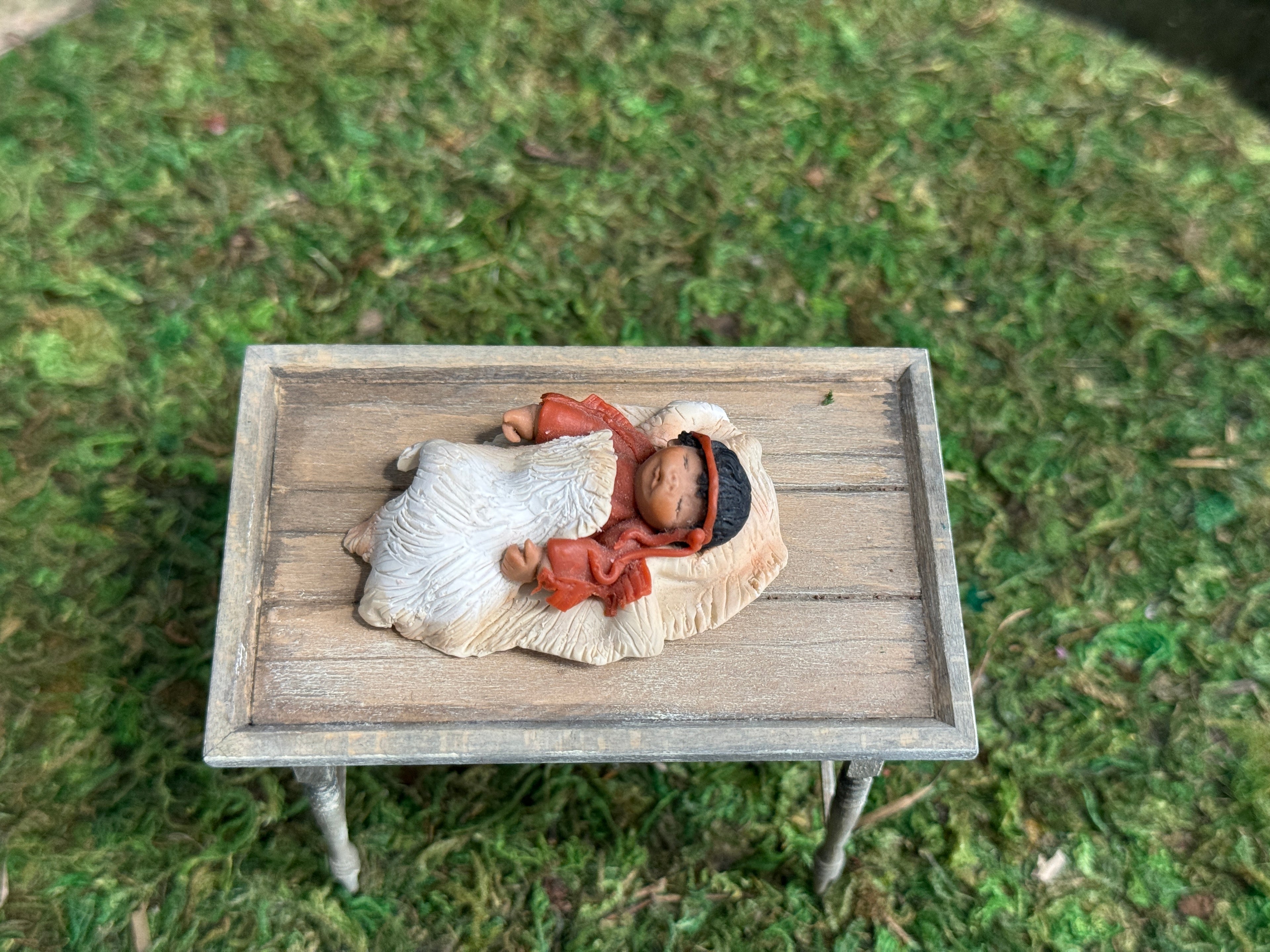 Signed Sculpted Clay Sleeping Native American Baby Doll Figurine, laying on a small table, top view