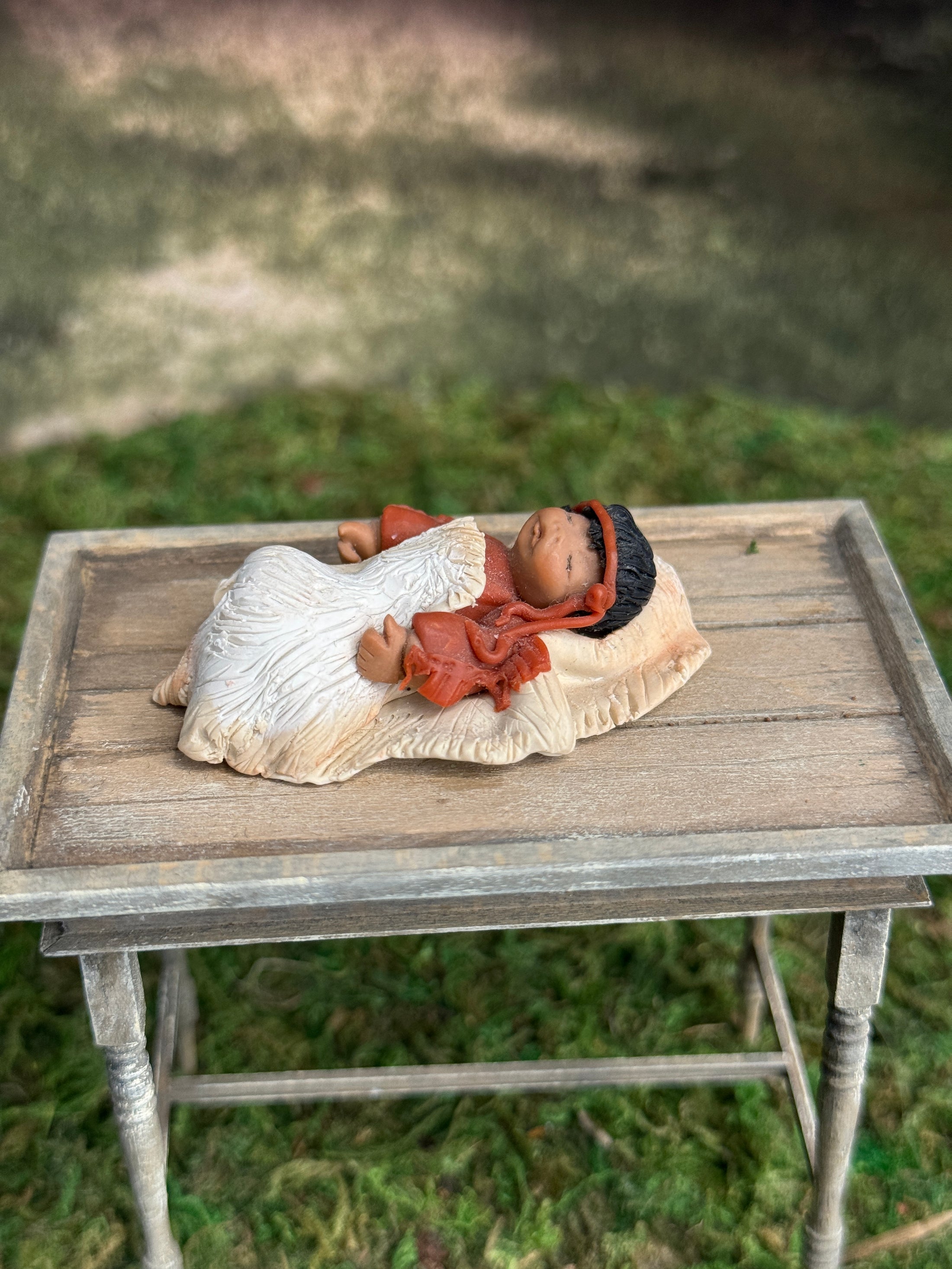 Signed Sculpted Clay Sleeping Native American Baby Doll Figurine, laying on a table, left side view