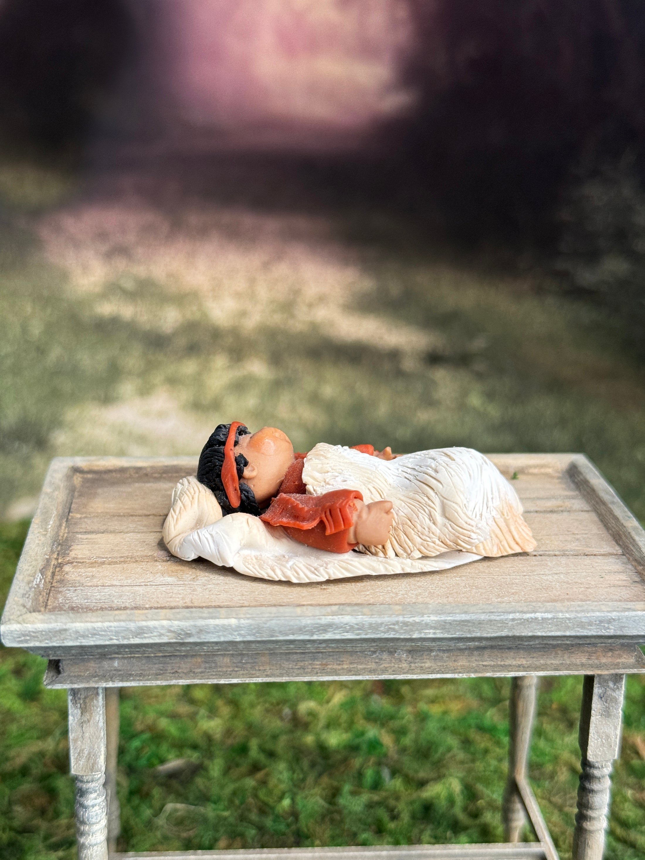 Signed Sculpted Clay Sleeping Native American Baby Doll Figurine, laying on a table, right side view