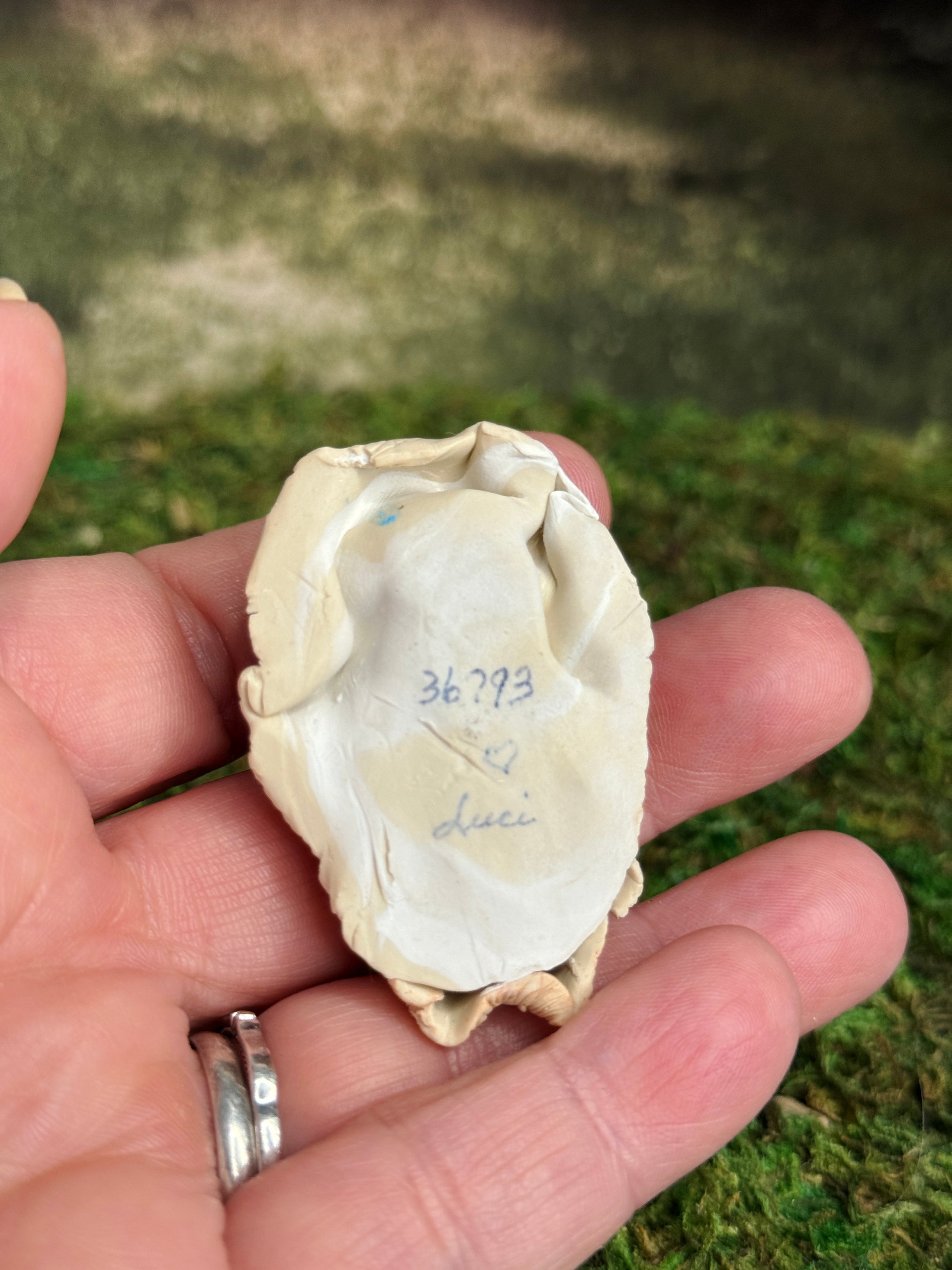 Signed Sculpted Clay Sleeping Native American Baby Doll Figurine, laying in a hand, underside view