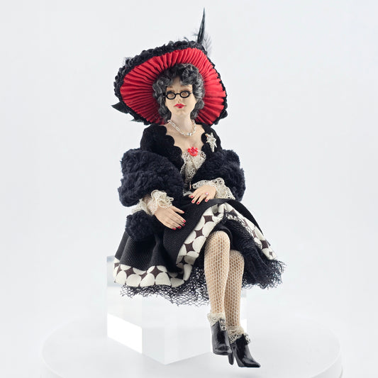 “Winter Lady” Doll with a black and white outfit and red hat on a white background