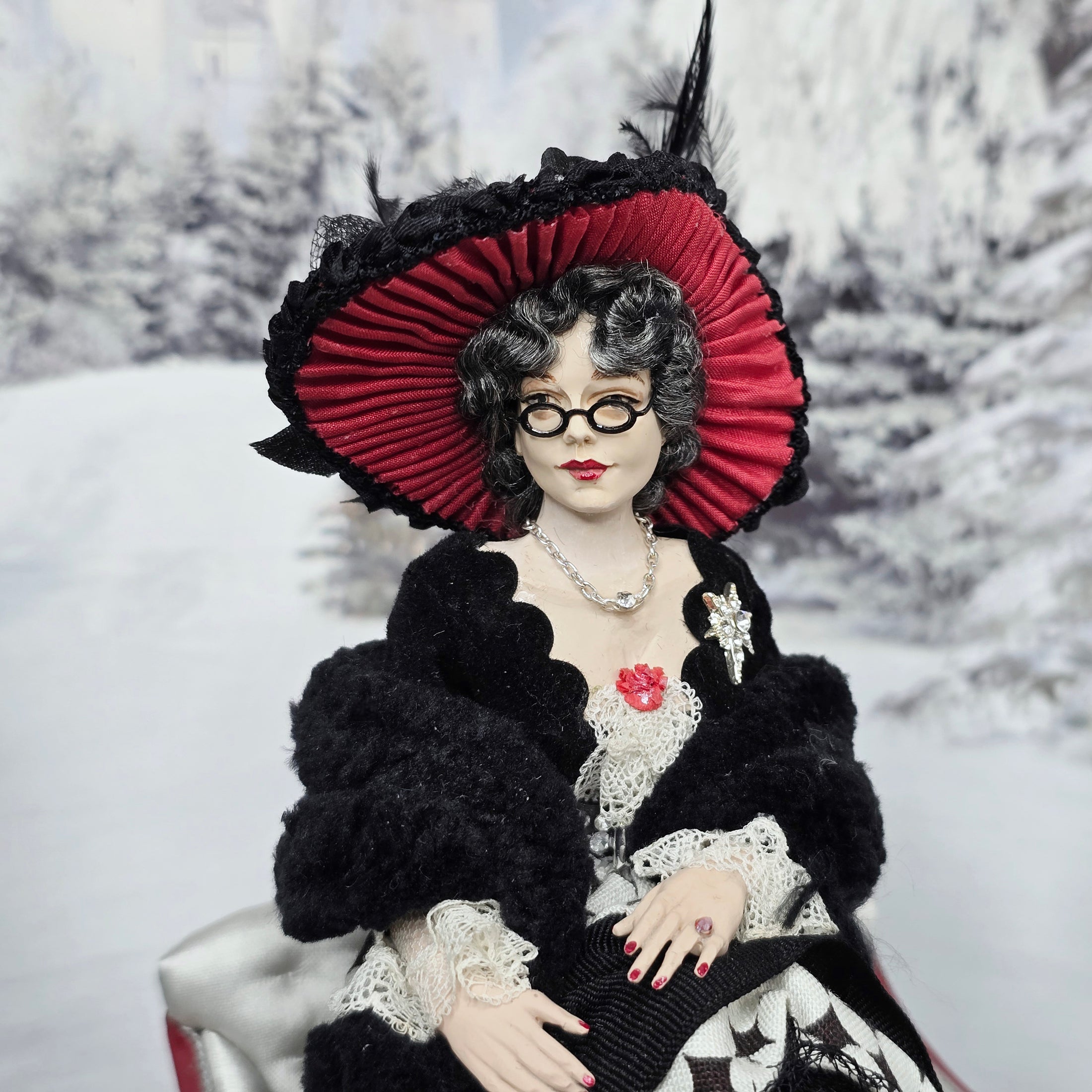 “Winter Lady” Doll with a red and black hat in a snowy landscape
