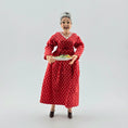 Load image into Gallery viewer, Lady doll wearing a red polka dot dress holding a plate of cookies on a plain background
