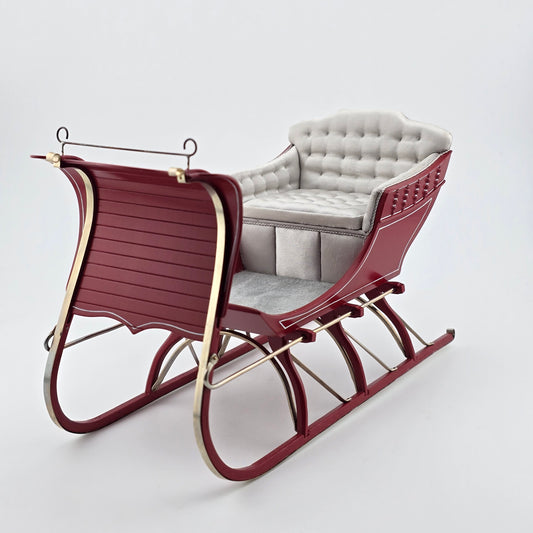 red sleigh with white cushioned seat on a white background