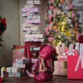 Load image into Gallery viewer, back view of a Hand-Sculpted Clay Elf Boy in Raspberry Pink in a festive setting with Christmas tree and presents.

