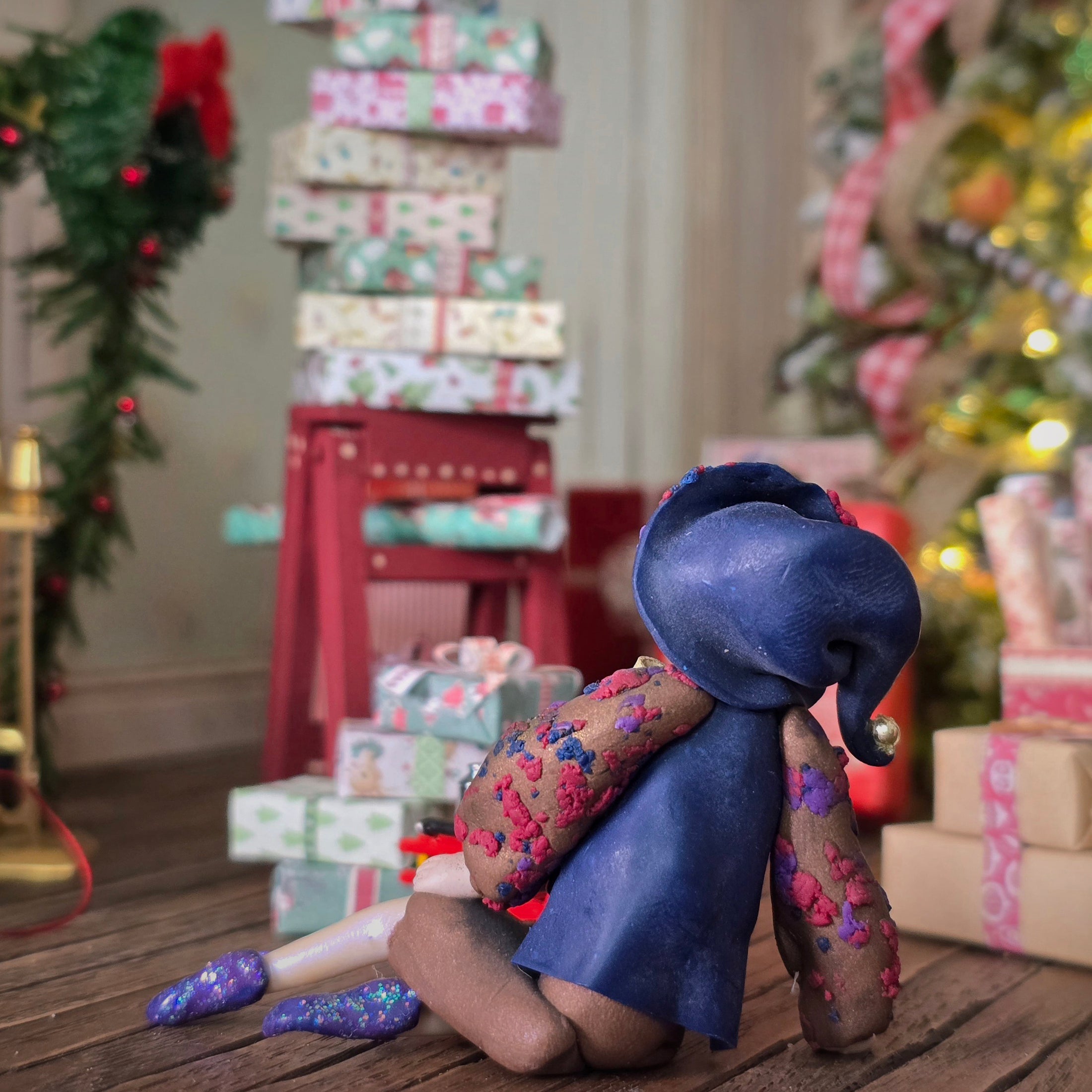 back view of Sculpted clay elf boy doll wearing a purple outfit