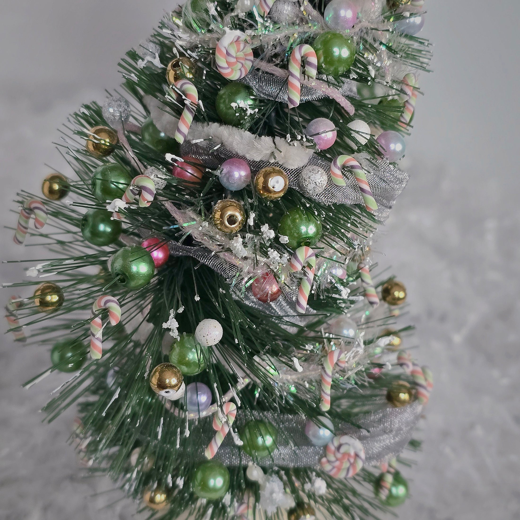 Decorative Christmas tree with colorful ornaments on a gray background