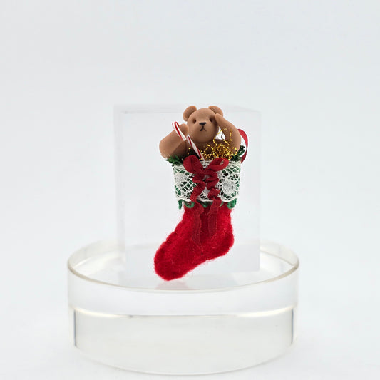Small teddy bear in a red stocking on a white background