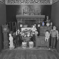 Load image into Gallery viewer, Black and white miniature dollhouse scene with furniture and decorative items.
