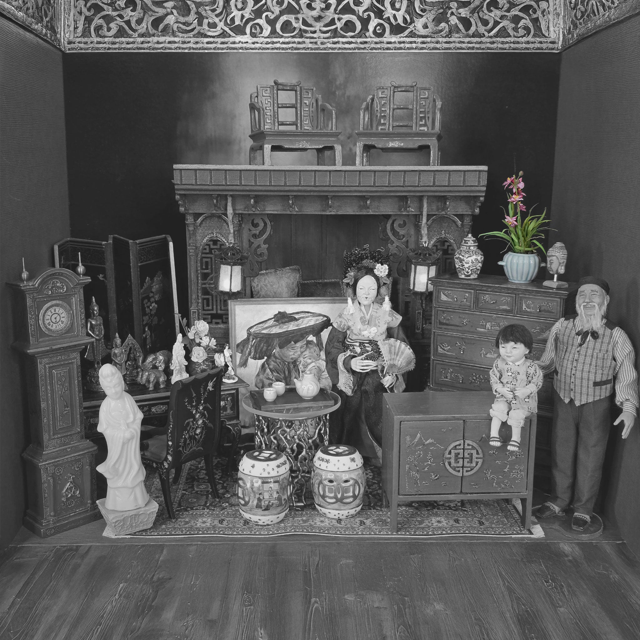 Black and white miniature room setup with furniture and decorative items.