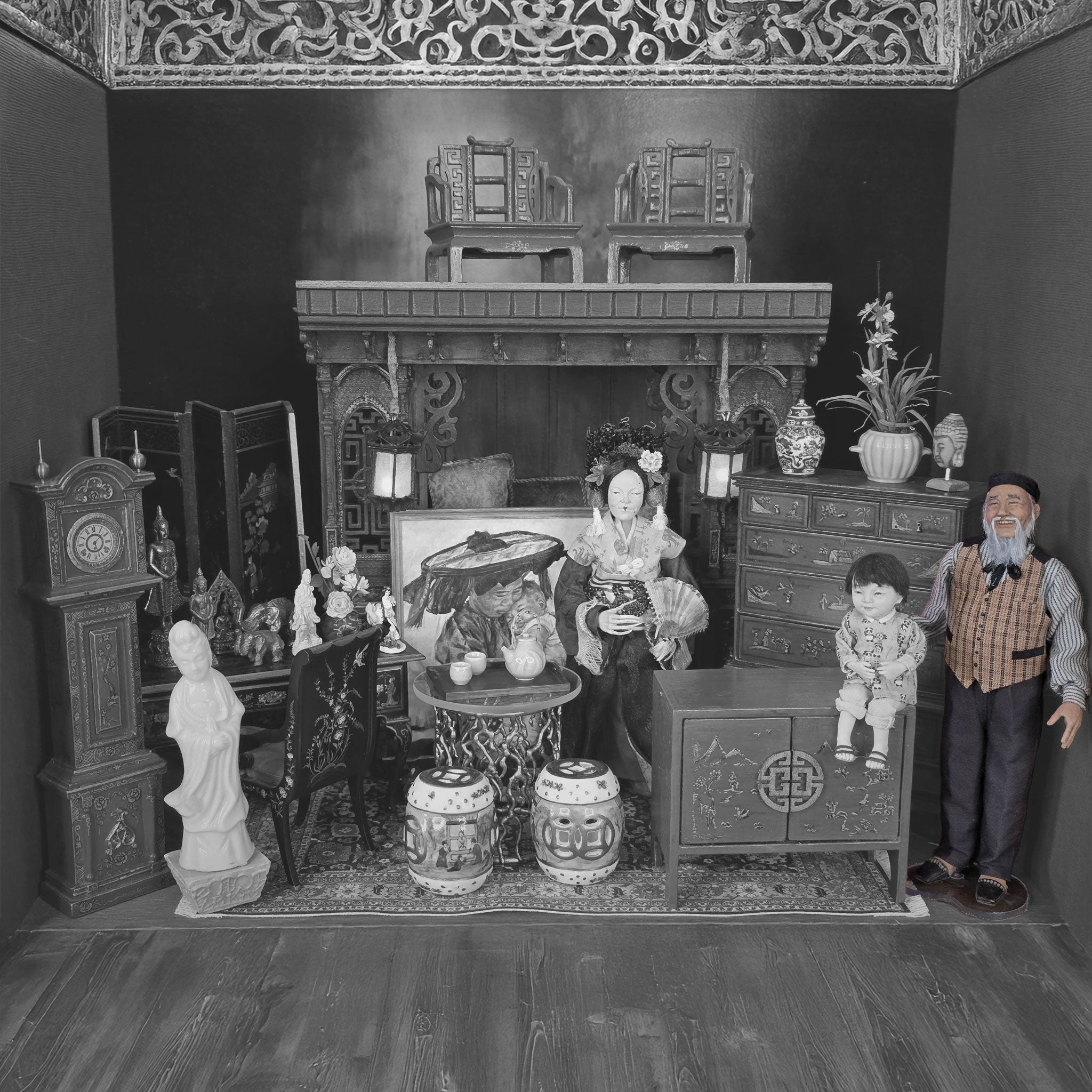 Black and white miniature room setup with furniture and decorative items.