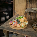 Load image into Gallery viewer, Assorted small appetizers on a wooden board with a rustic background
