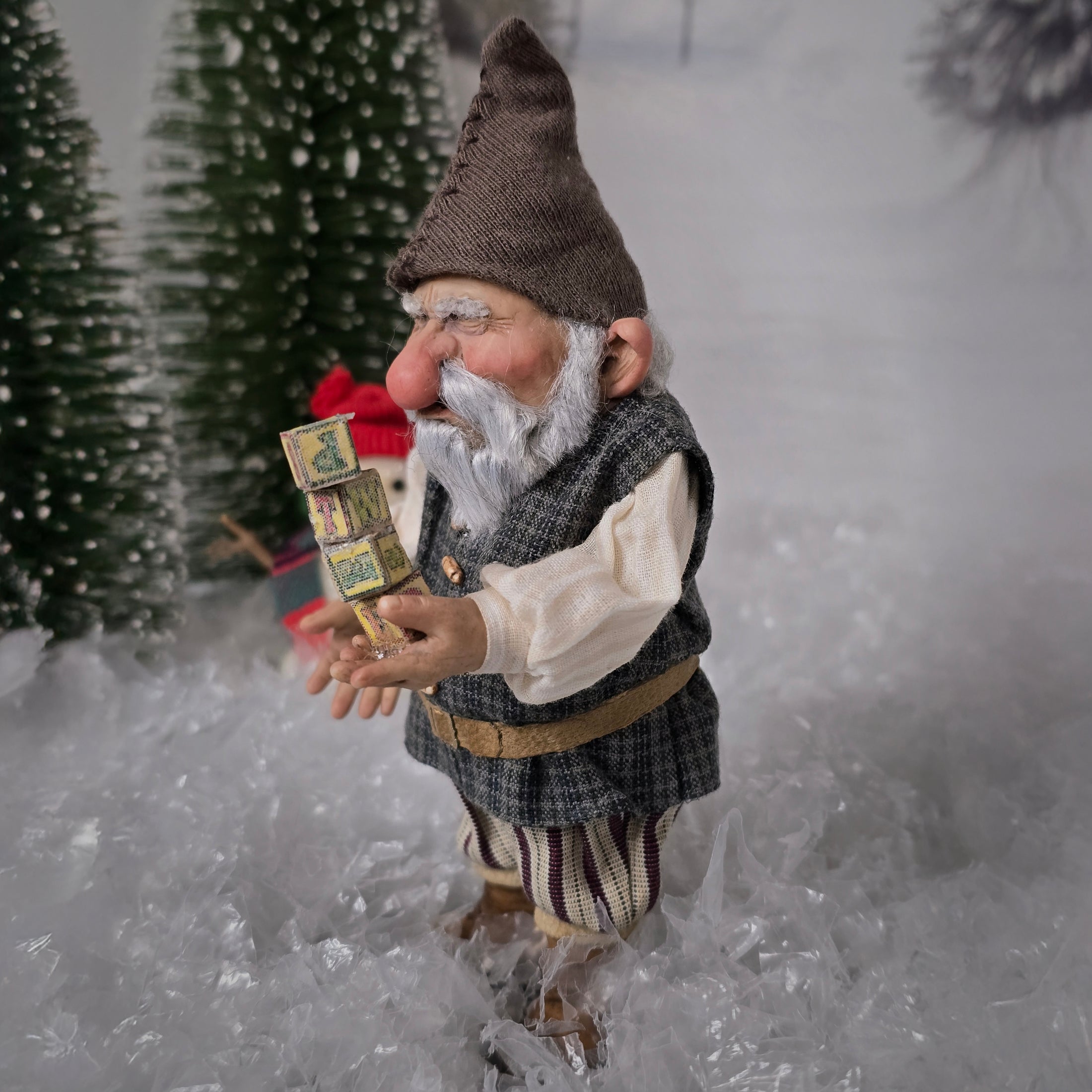 Sharon Cariola Elf dollhouse doll  in a snowy landscape holding a box of matches.