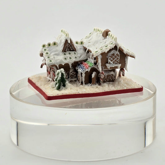 Gingerbread house miniature on a clear base with a white background