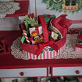 Load image into Gallery viewer, Decorative Christmas gift basket with red and white striped ribbon on a festive background.
