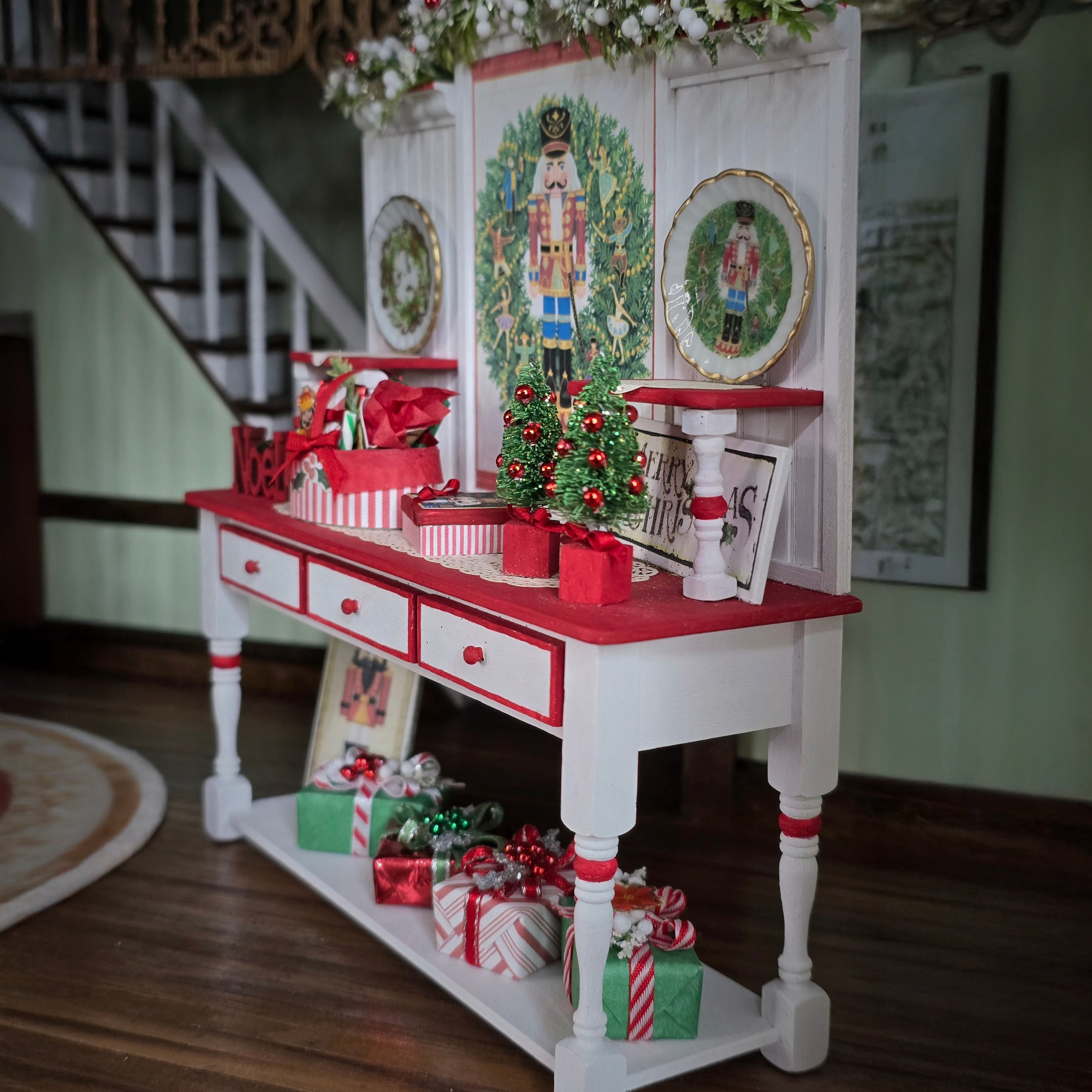 Decorative Christmas setup with a red and white table, nutcrackers, and gift boxes.