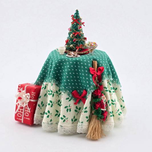 Decorative Christmas scene with a small tree, presents, and a broom on a white background