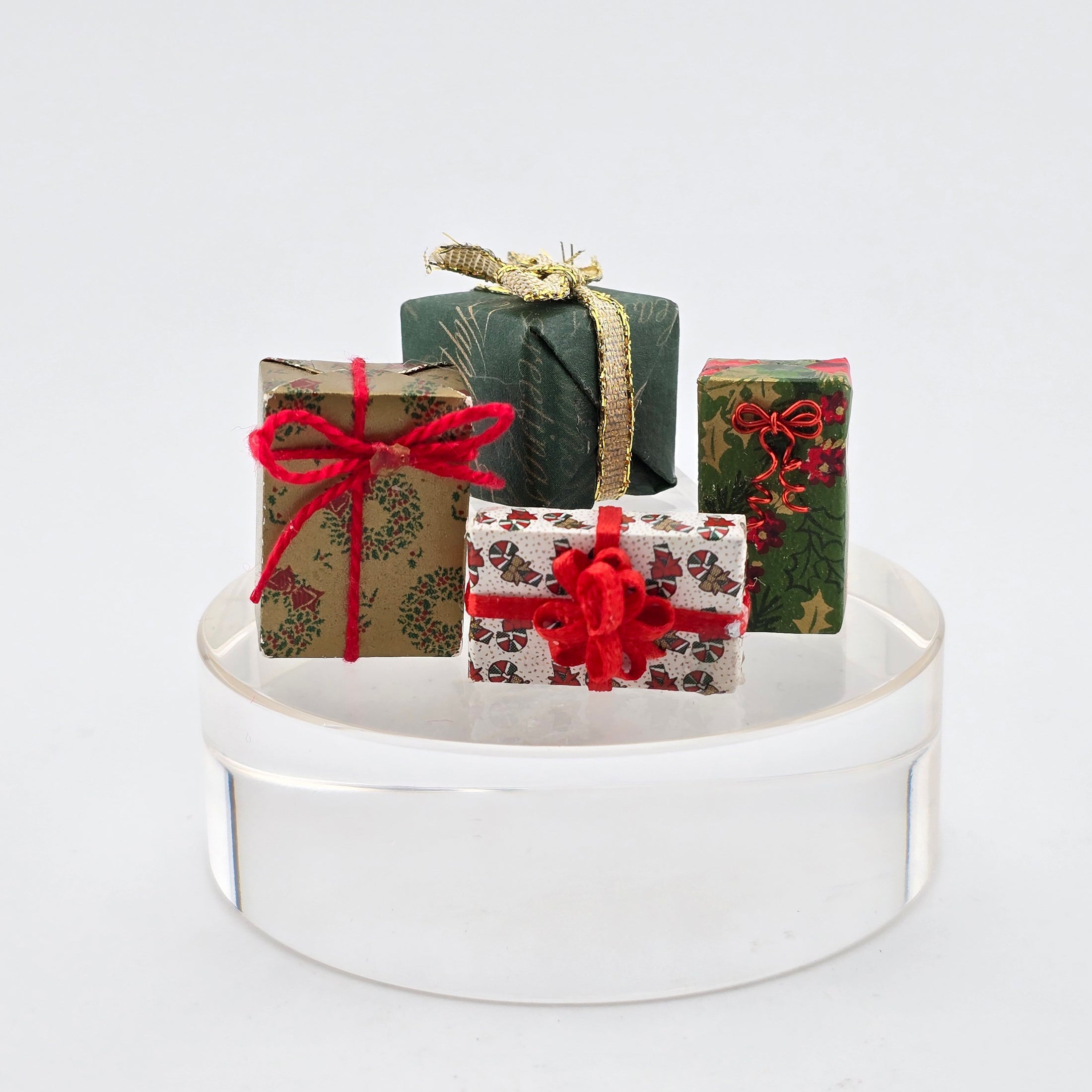 Decorative gift boxes with ribbons on a white stand against a light gray background