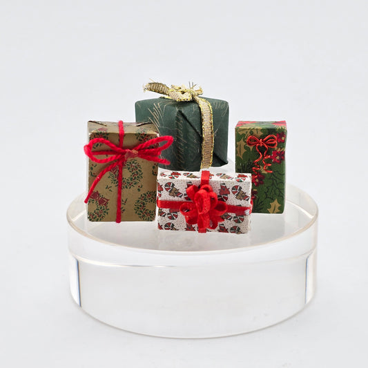 Decorative gift boxes with ribbons on a white stand against a light gray background