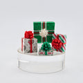 Decorative arrangement of small gift boxes on a white stand with a light gray background