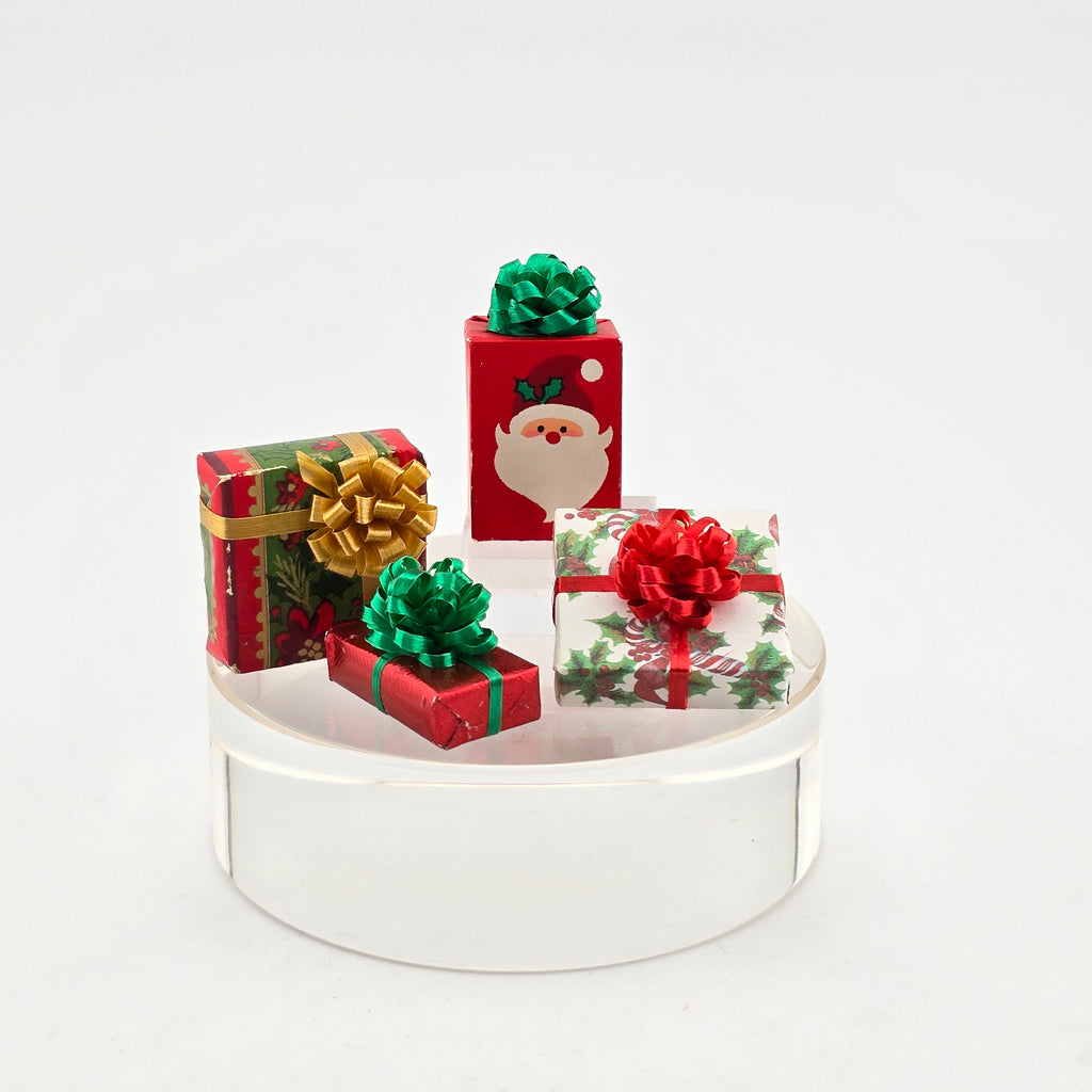 Set of Christmas-themed gift boxes with decorative bows on a white base.