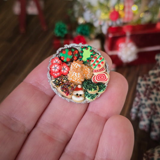 miniature dollhouse cookies on platter, held in hand