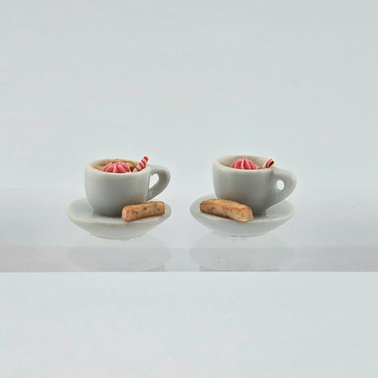 Pair of miniature hot cocoa cups with cream and biscotti