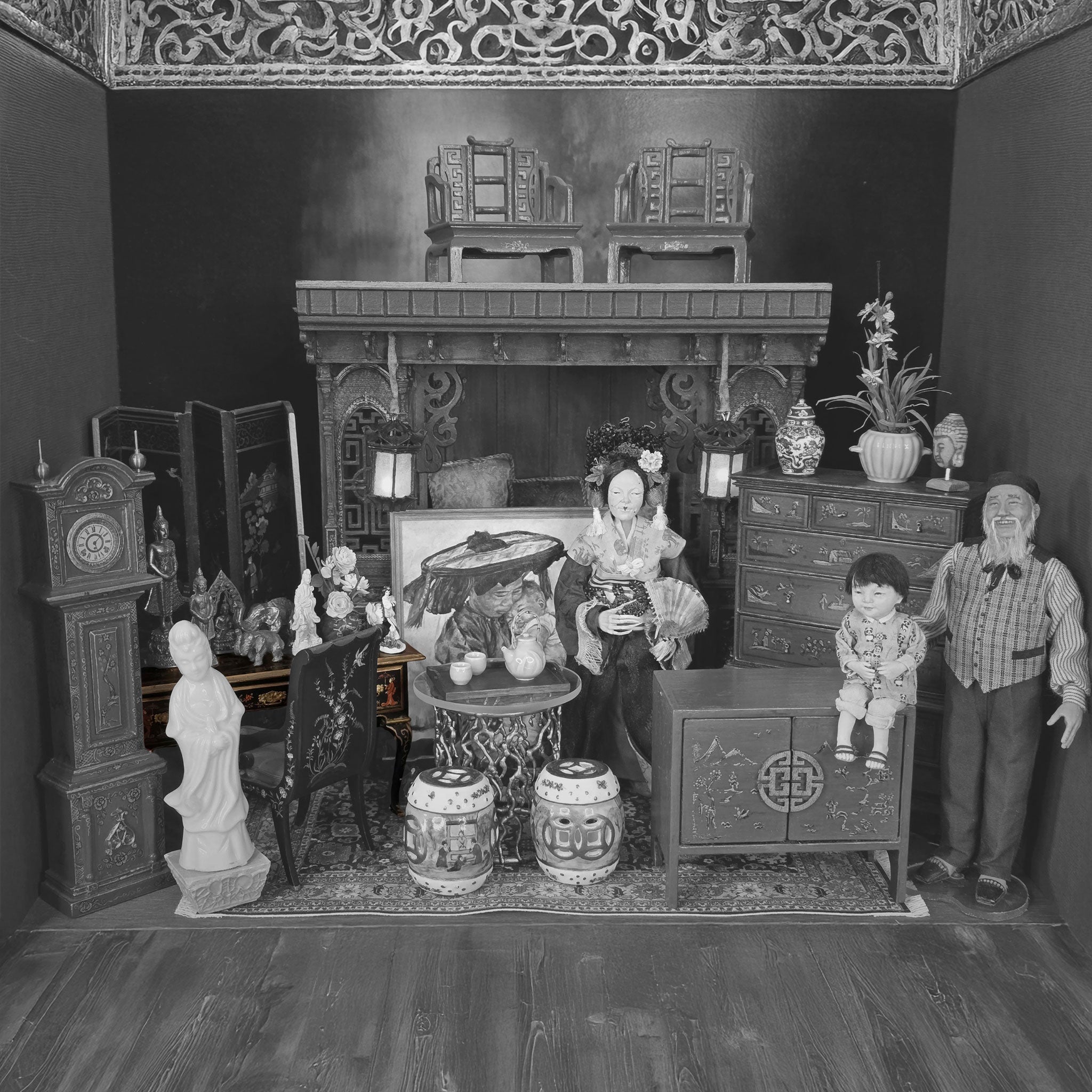 Black and white miniature room setup with furniture and decorative items.
