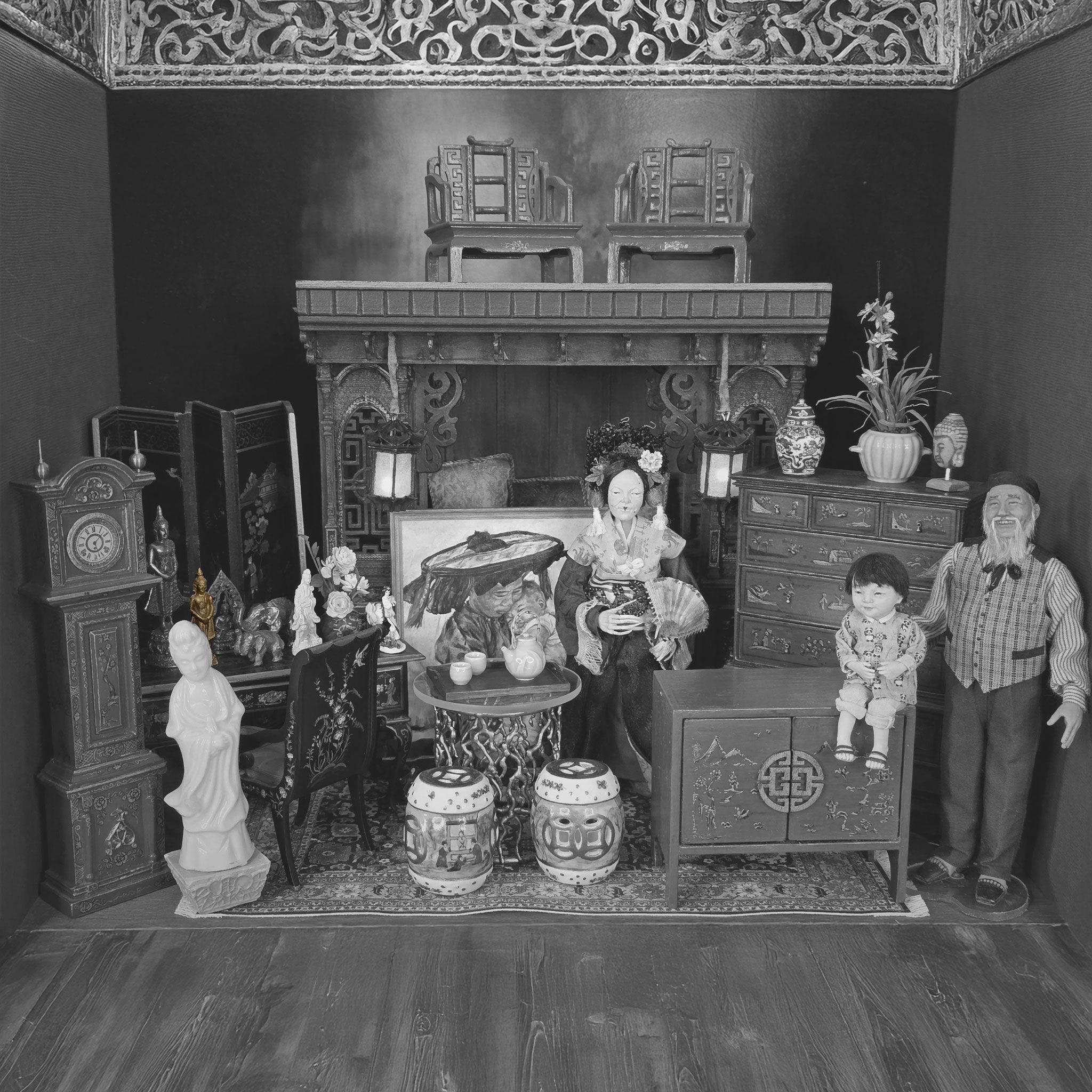 Black and white miniature room setup with furniture and decorative items.