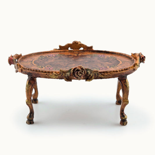 Decorative oval miniature coffee table with intricate designs on a white background