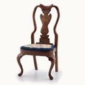 Wooden chair with a petit point floral seat on a white background