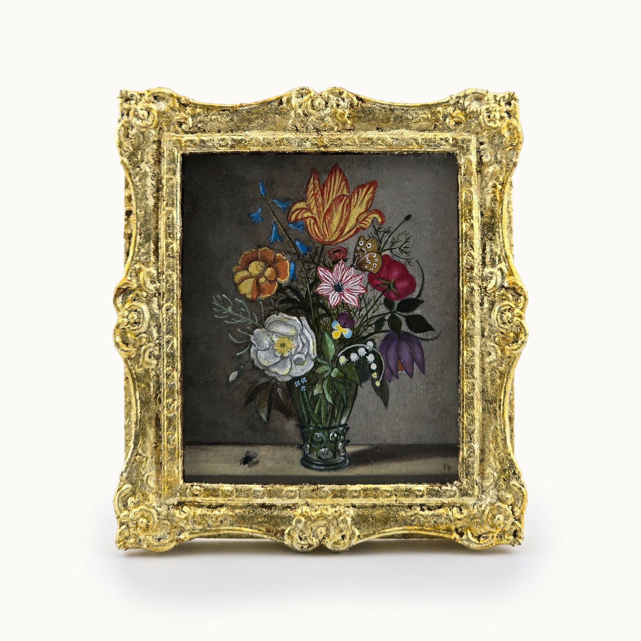 Decorative miniature gold frame with a floral arrangement oil painting inside on a white background. By Fatima Dona