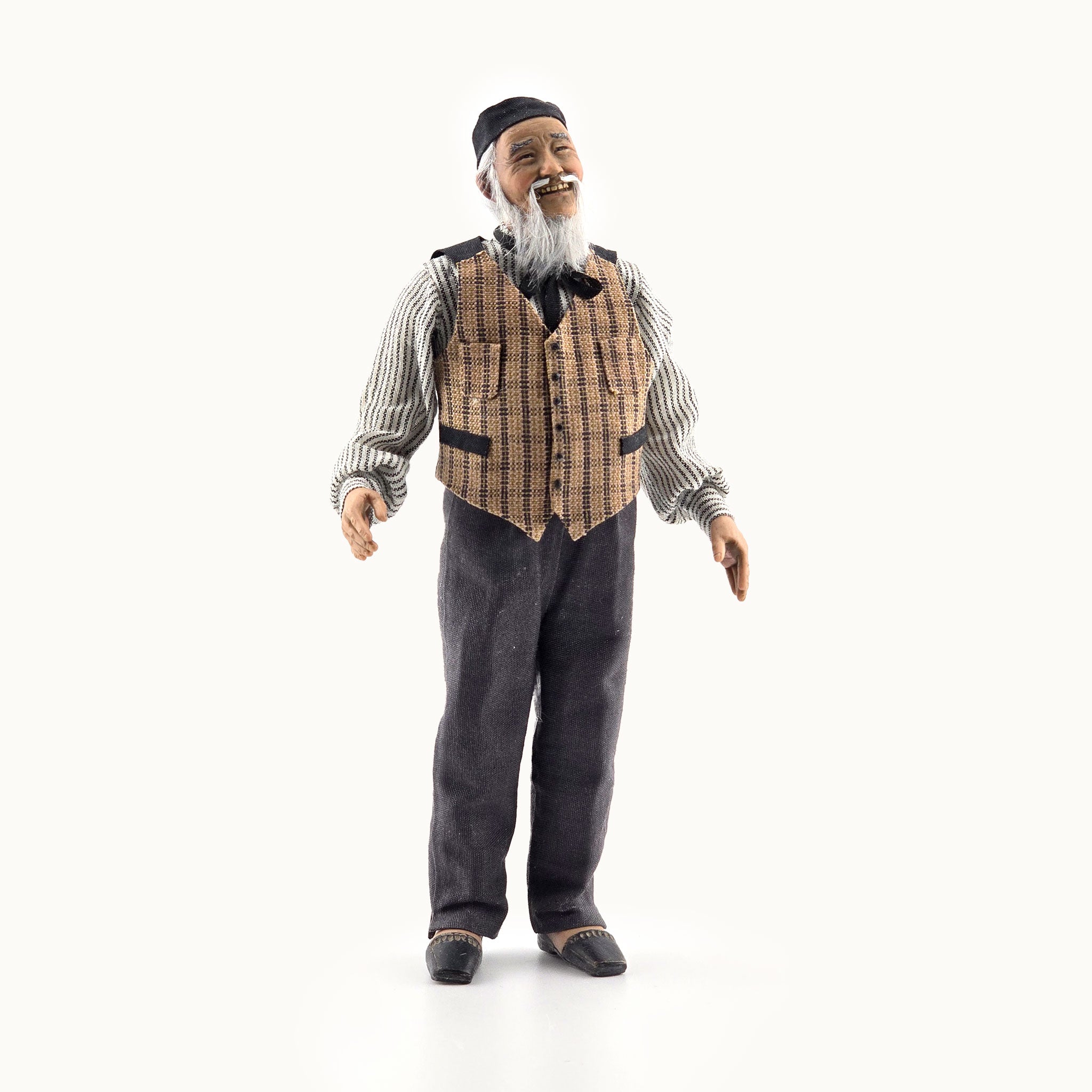 Vintage-style clay dollhouse doll, an elderly man with a checkered vest and bow tie on a white background