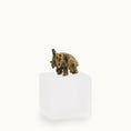 Load image into Gallery viewer, Bronze baby elephant figurine on a white pedestal against a white background
