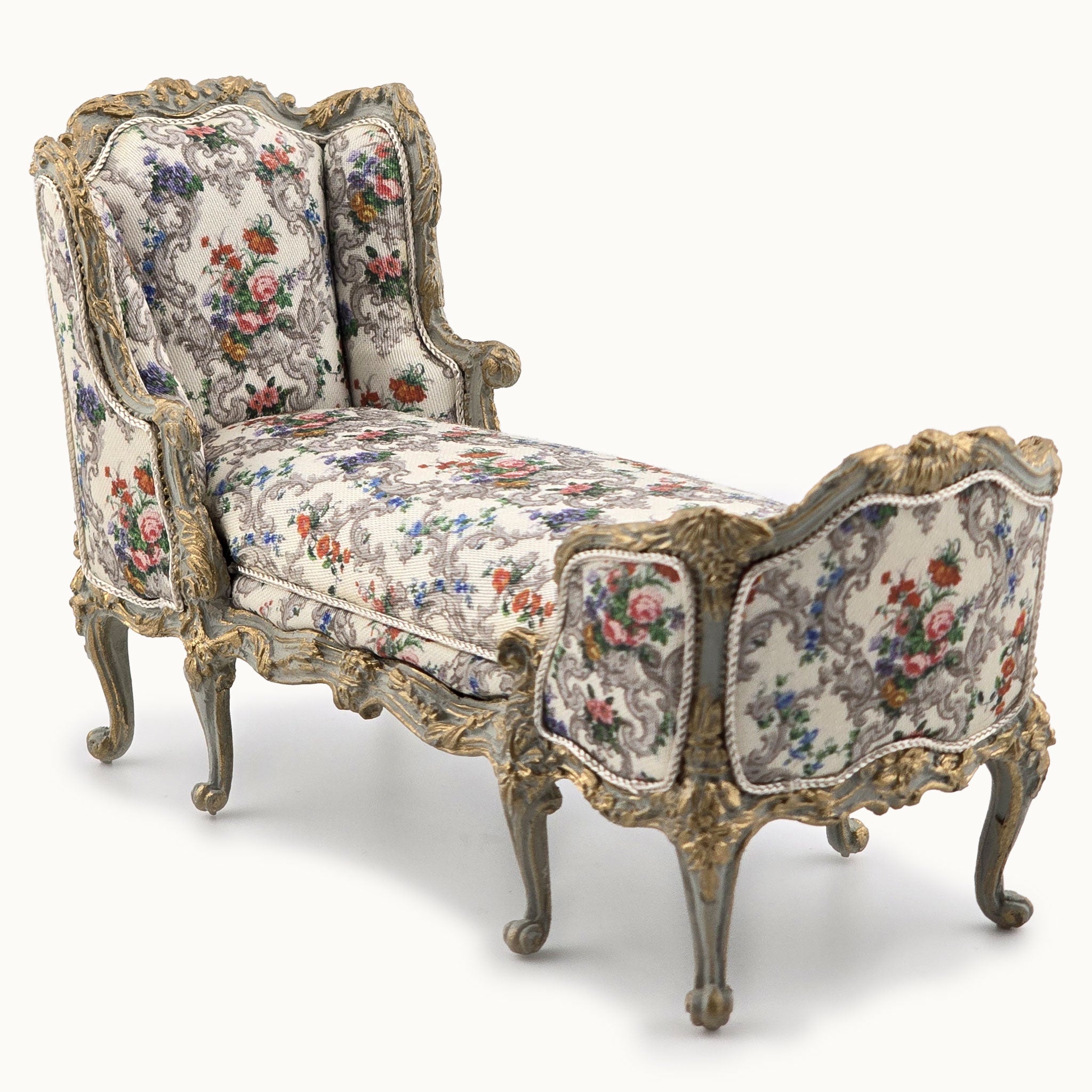 Decorative chaise chair with floral pattern and ornate carved frame on a white background