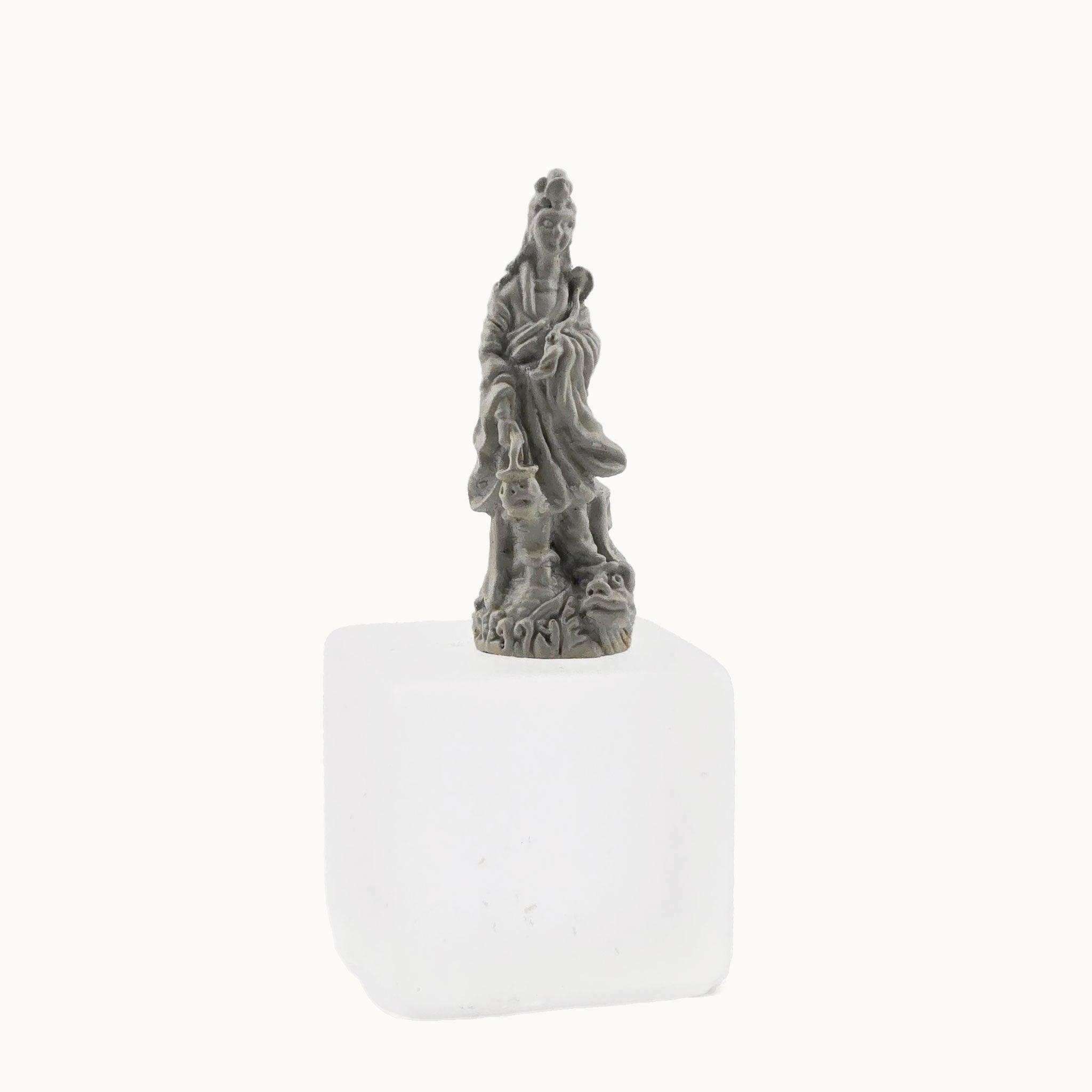 Statue of a figure on a white base against a white background