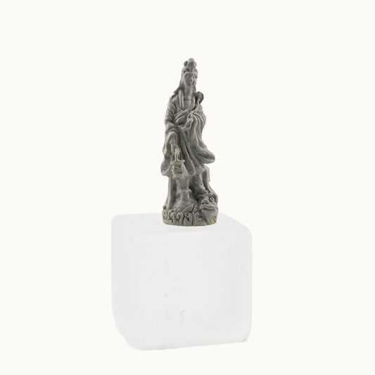 Statue of a figure on a white base against a white background