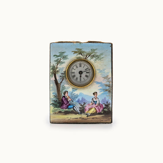 Miniature rectangular clock with painted scene of two people sitting under a tree on a white background