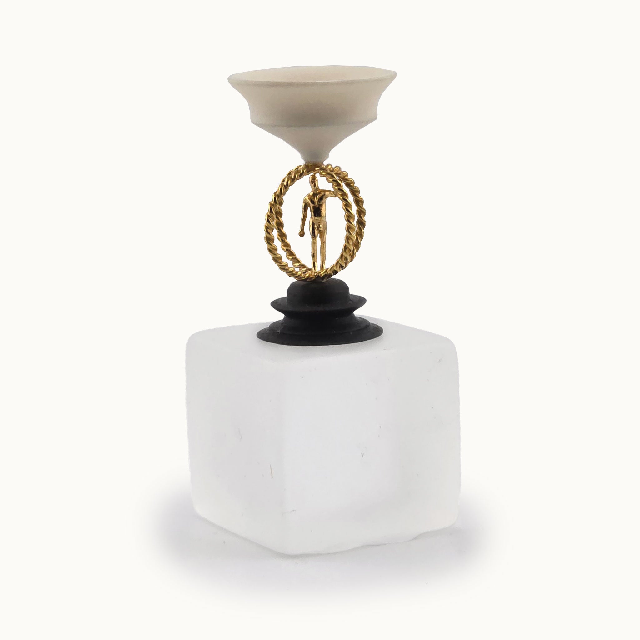Decorative miniature object with a white compote bowl top base, a gold circular design, and a black carved round base on a white background