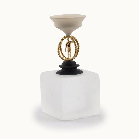 Decorative miniature object with a white compote bowl top base, a gold circular design, and a black carved round base on a white background