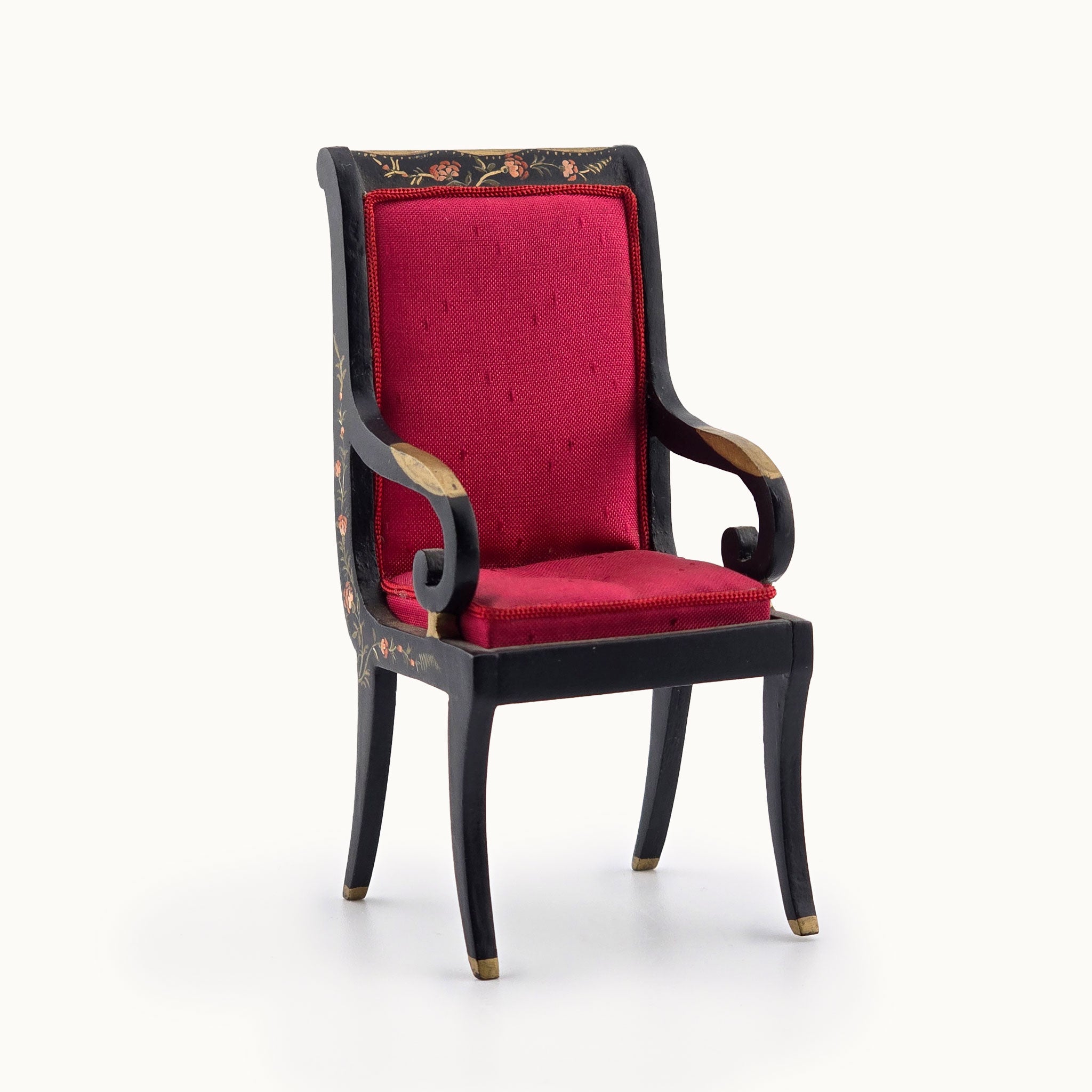 Decorative armchair with red cushion and black frame on a white background