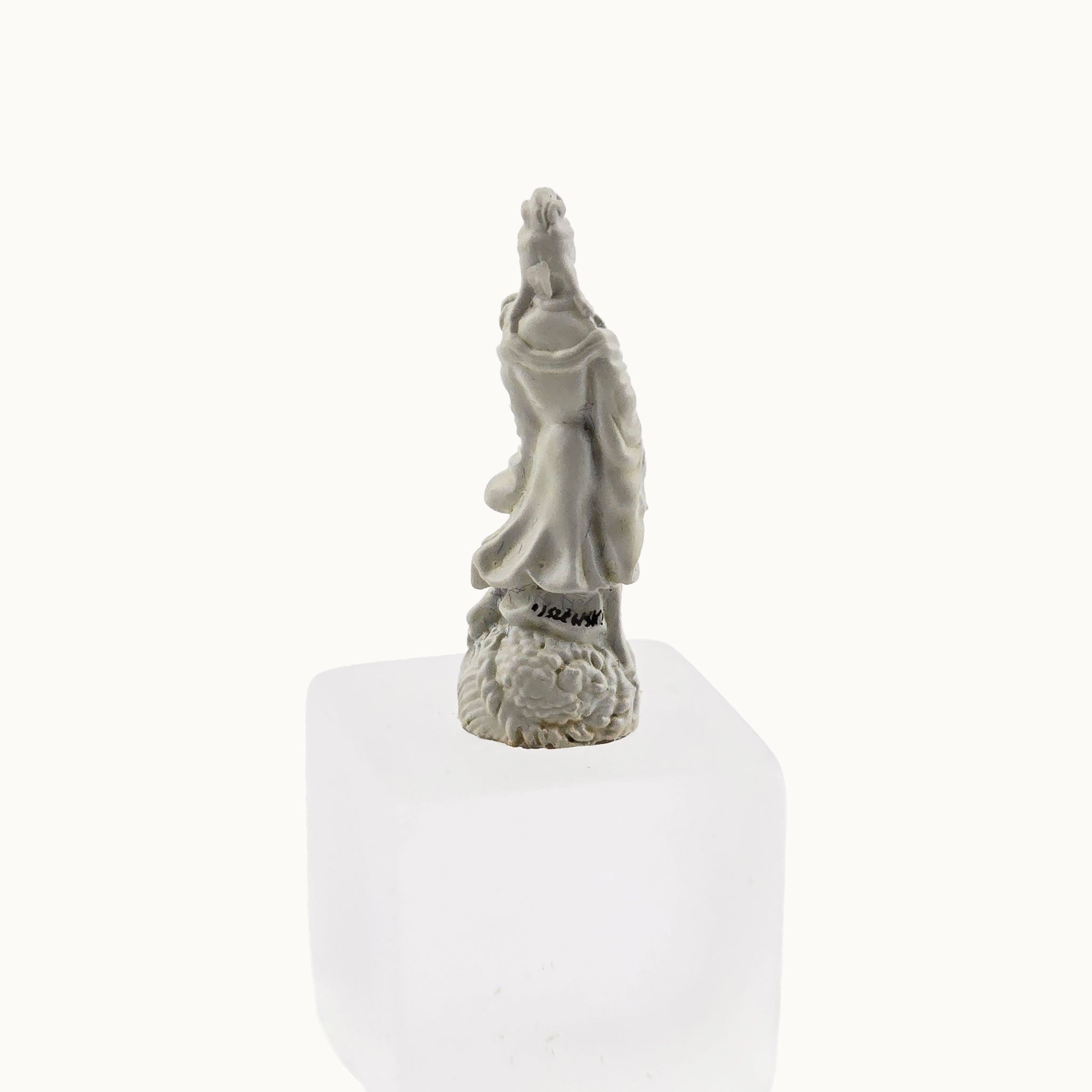 Statue of a woman on a white pedestal with a white background