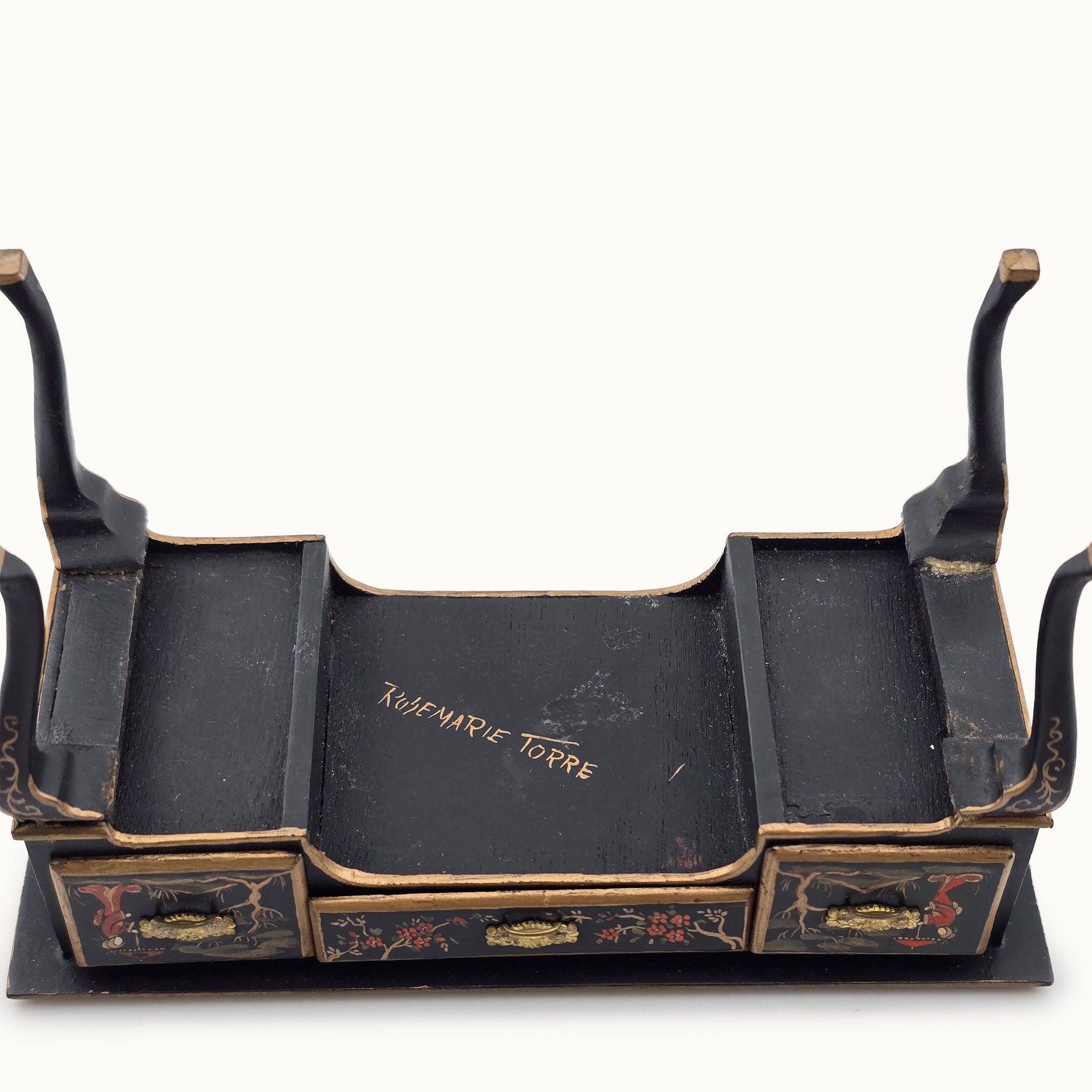 Underside of desk with the artist signature in gold 'Rosemarie Torre' on a white background